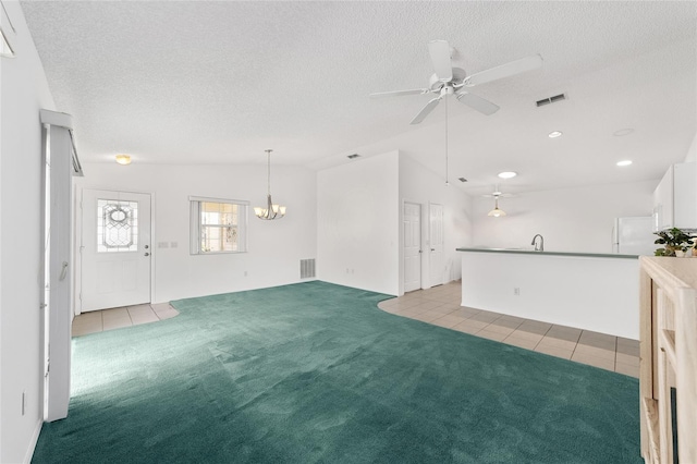 unfurnished living room featuring sink, ceiling fan with notable chandelier, light colored carpet, and a textured ceiling