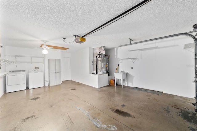 garage with a garage door opener, sink, washing machine and dryer, and heating unit