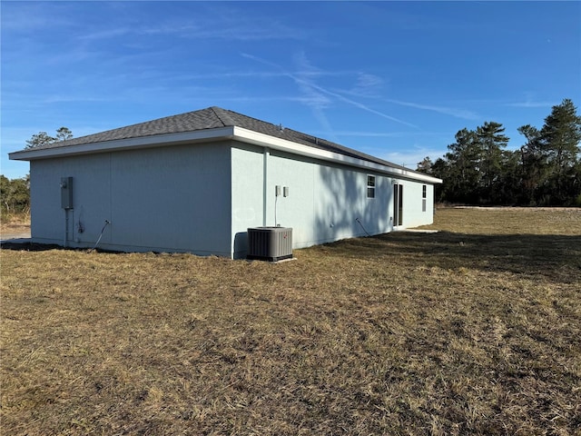 view of home's exterior featuring central air condition unit and a lawn