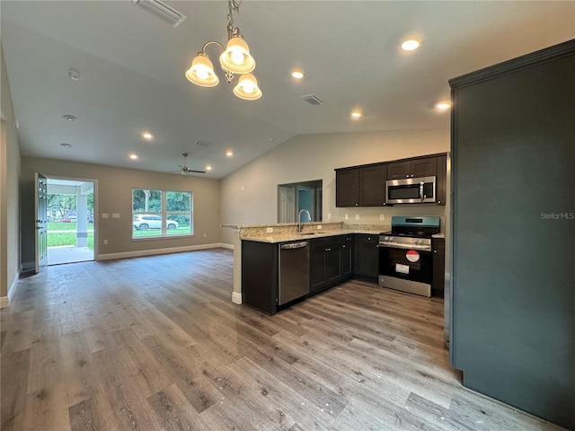 kitchen featuring pendant lighting, sink, appliances with stainless steel finishes, light stone counters, and kitchen peninsula