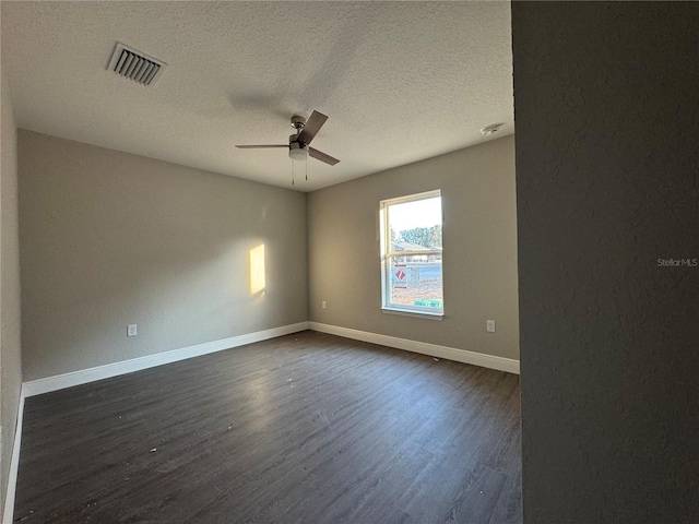 empty room with a textured ceiling, dark wood-type flooring, and ceiling fan