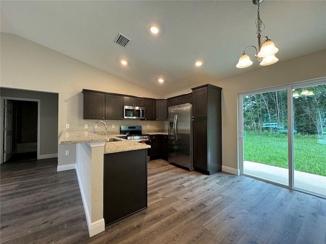 kitchen with sink, kitchen peninsula, pendant lighting, stainless steel appliances, and light stone countertops