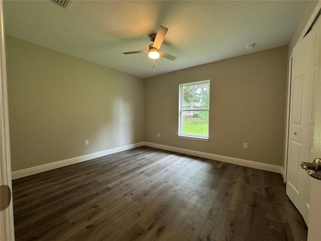 unfurnished bedroom with dark wood-type flooring, ceiling fan, and a textured ceiling