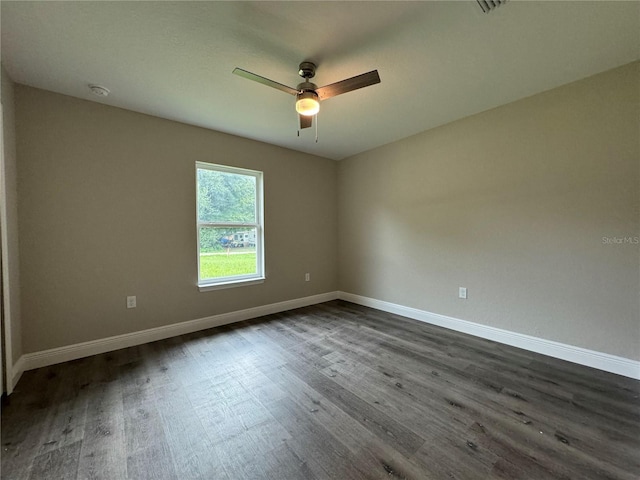 spare room with dark hardwood / wood-style flooring and ceiling fan