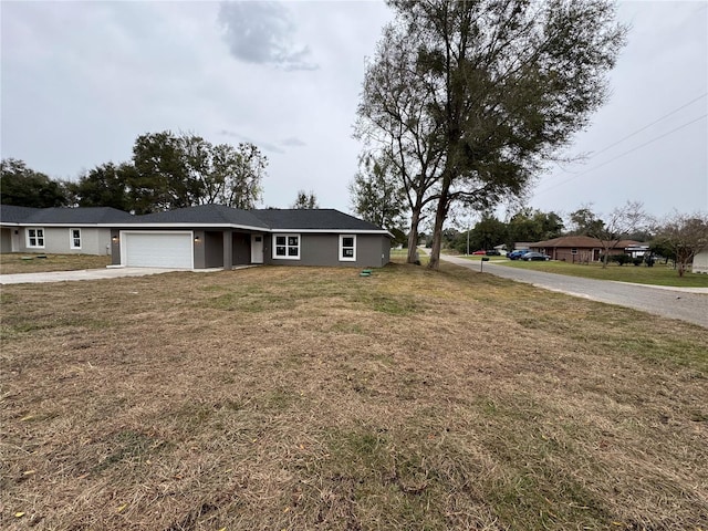 ranch-style house featuring a front lawn, an attached garage, and driveway