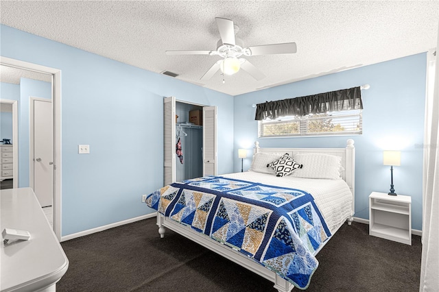 bedroom featuring ceiling fan, a closet, a textured ceiling, and dark colored carpet