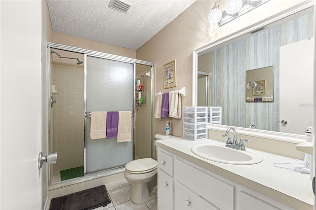 bathroom featuring walk in shower, toilet, a textured ceiling, vanity, and tile patterned flooring