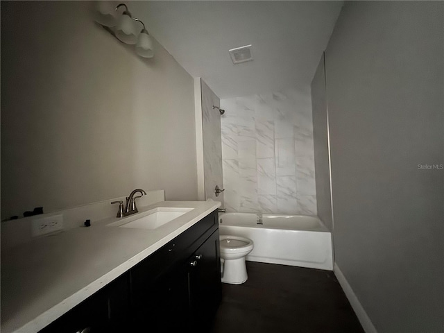 full bathroom with tiled shower / bath, vanity, and toilet