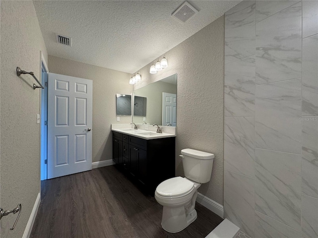 bathroom featuring a sink, visible vents, and a textured wall