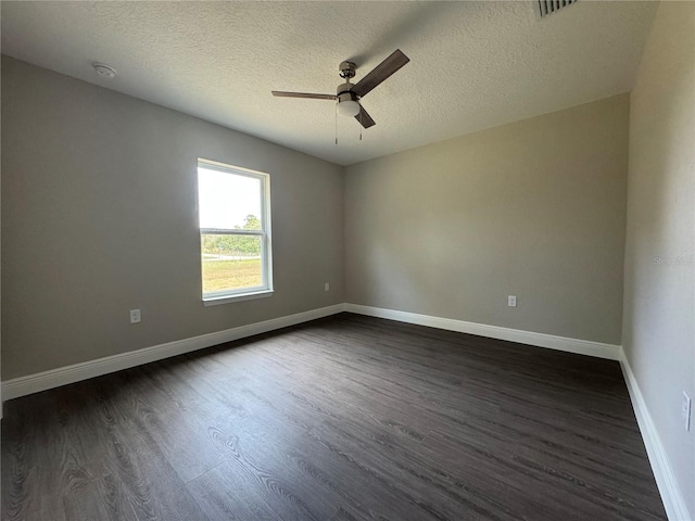 unfurnished room with visible vents, baseboards, dark wood-style flooring, and ceiling fan