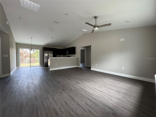 unfurnished living room featuring visible vents, baseboards, dark wood finished floors, vaulted ceiling, and a ceiling fan