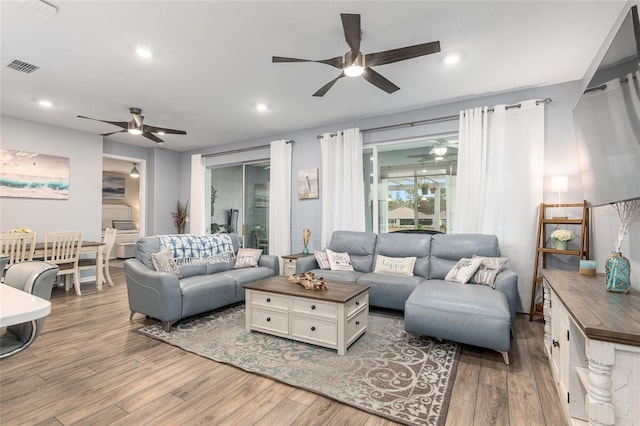 living room featuring hardwood / wood-style floors and ceiling fan