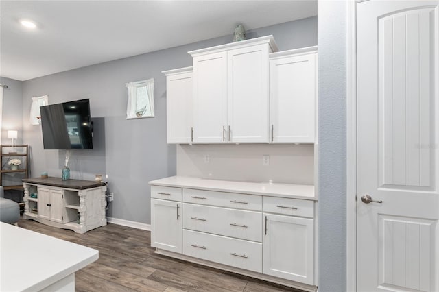 kitchen with dark hardwood / wood-style floors and white cabinets