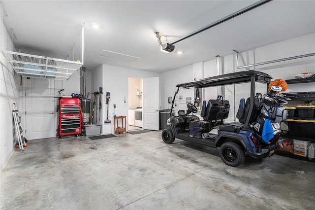 garage featuring a garage door opener, water heater, and washing machine and clothes dryer