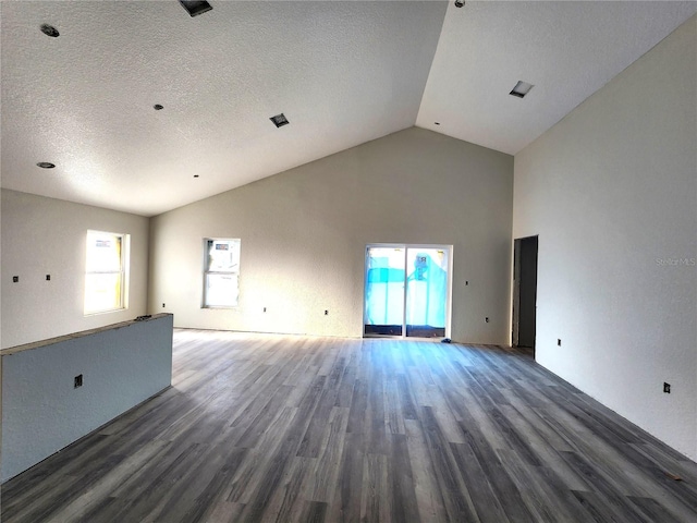 unfurnished living room with high vaulted ceiling, wood finished floors, and a textured ceiling