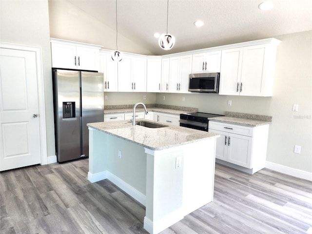 7799 SW 132nd Pl Unit 10, Ocala, FL 34473 - kitchen featuring appliances with stainless steel finishes, lofted ceiling, an island with sink, white cabinetry, and light wood-type flooring