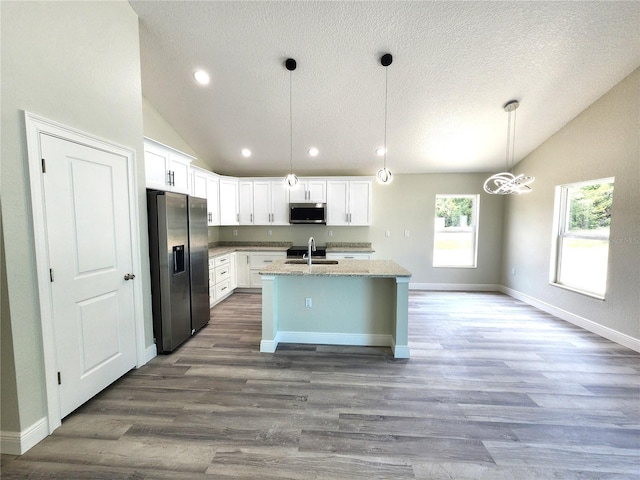 7799 SW 132nd Pl Unit 10, Ocala, FL 34473 - kitchen with appliances with stainless steel finishes, vaulted ceiling, white cabinetry, an island with sink, and dark wood finished floors