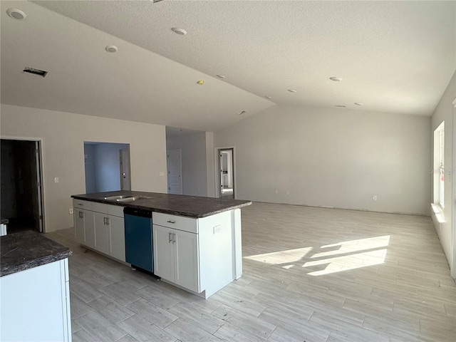 kitchen with vaulted ceiling, a kitchen island, dishwasher, sink, and white cabinets