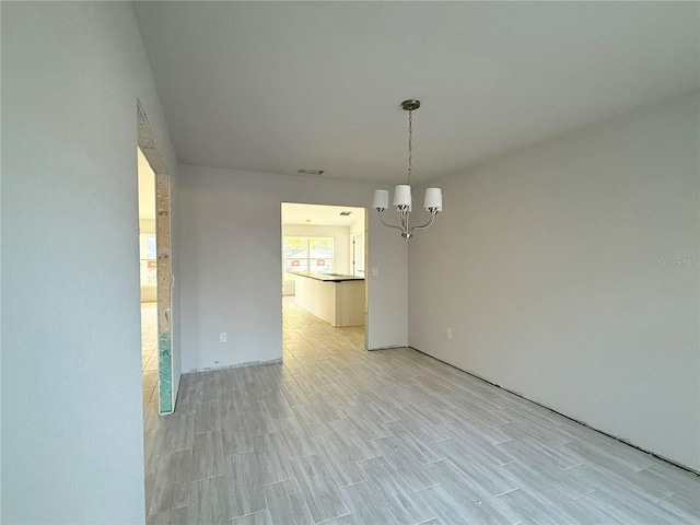 unfurnished dining area with a notable chandelier and light hardwood / wood-style floors