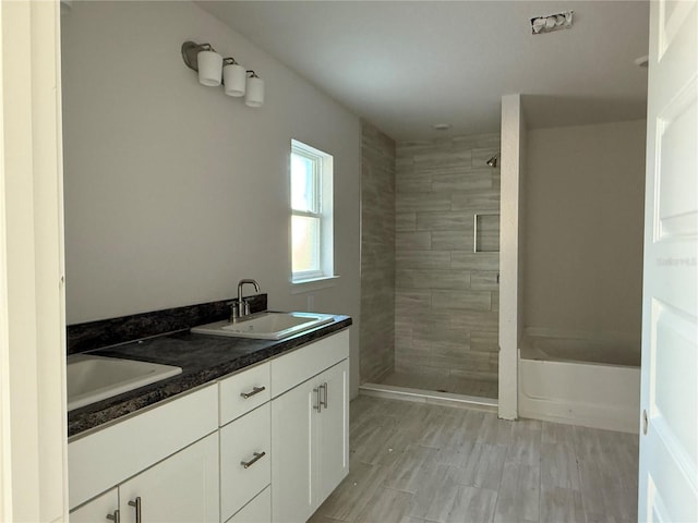 bathroom with vanity and a tile shower