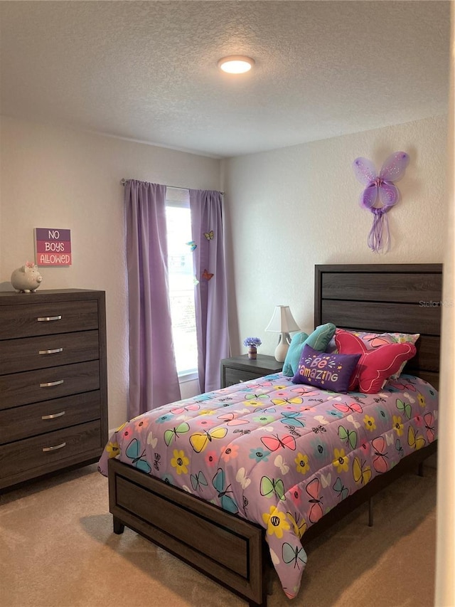 bedroom with light colored carpet and a textured ceiling