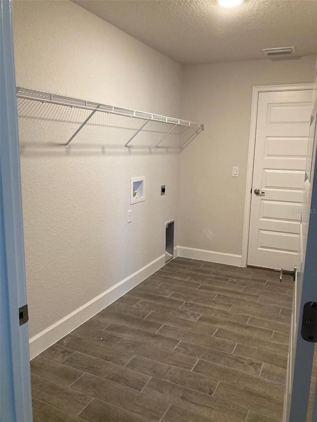 laundry area with dark wood-type flooring, hookup for an electric dryer, hookup for a washing machine, and a textured ceiling