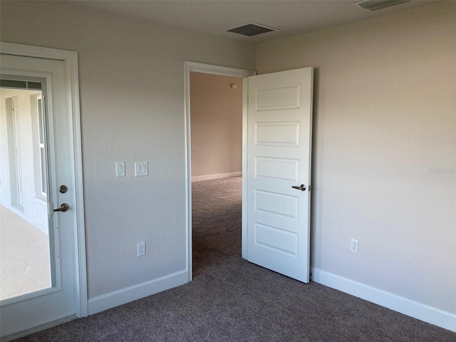 unfurnished room with dark carpet