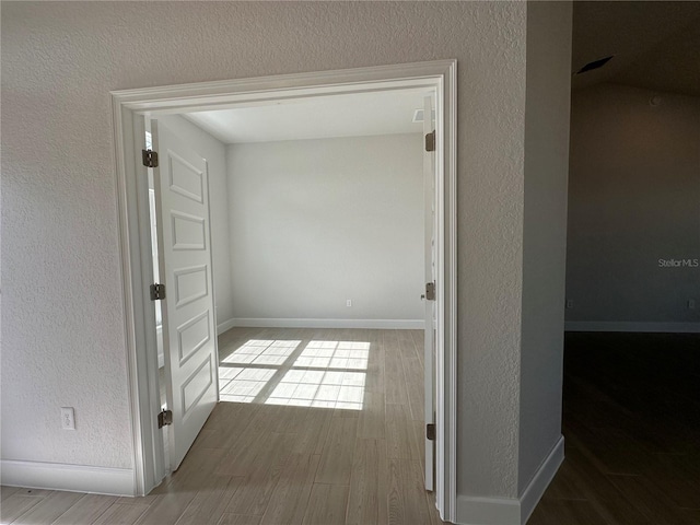 hallway with hardwood / wood-style floors