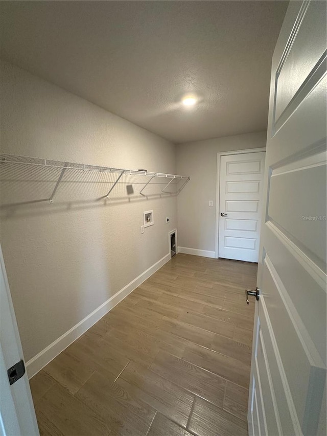 clothes washing area with washer hookup, hardwood / wood-style floors, hookup for an electric dryer, and a textured ceiling