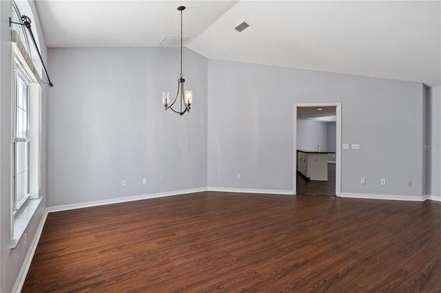 spare room with lofted ceiling, dark hardwood / wood-style flooring, and an inviting chandelier