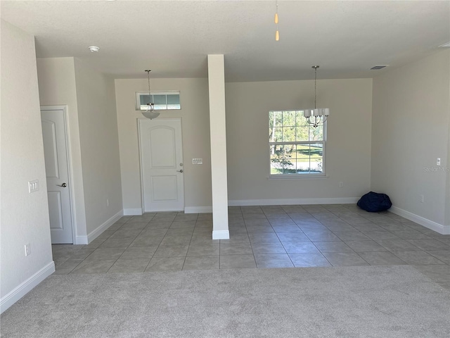 entrance foyer with light carpet, baseboards, a chandelier, and light tile patterned flooring