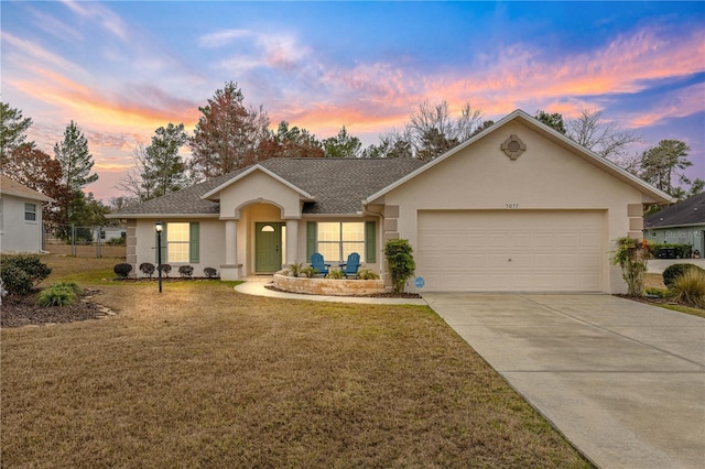 single story home featuring a garage and a lawn