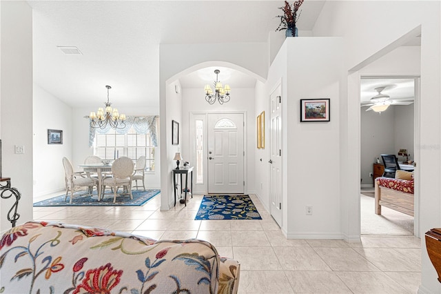 tiled entryway featuring an inviting chandelier