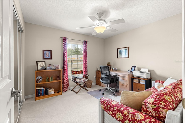 home office with light carpet, a textured ceiling, and ceiling fan