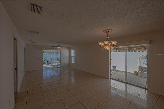 tiled spare room featuring ceiling fan with notable chandelier and a textured ceiling