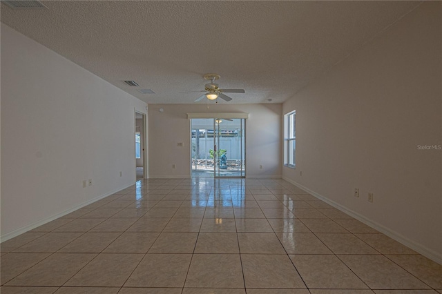 spare room featuring light tile patterned flooring, ceiling fan, and a textured ceiling