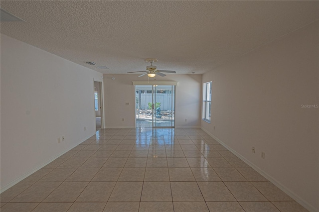 unfurnished room with light tile patterned flooring, ceiling fan, and a textured ceiling