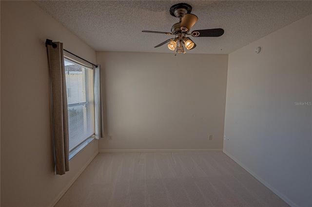 unfurnished room with ceiling fan, light colored carpet, and a textured ceiling