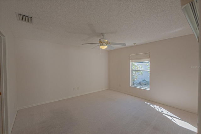 spare room featuring light carpet, a textured ceiling, and ceiling fan