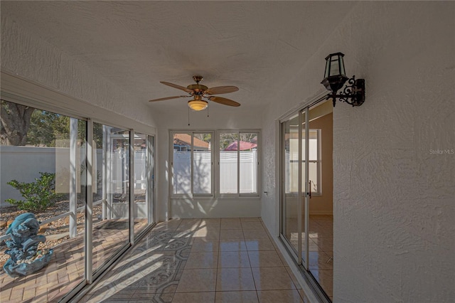 unfurnished sunroom with ceiling fan