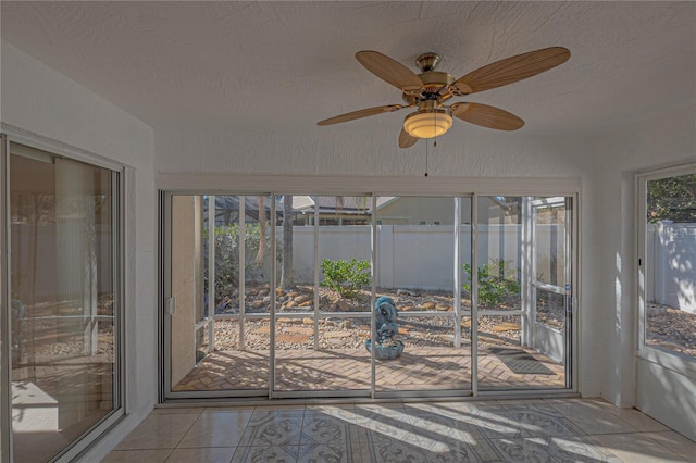 unfurnished sunroom featuring ceiling fan