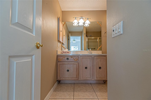 bathroom with walk in shower, tile patterned floors, vanity, and a textured ceiling