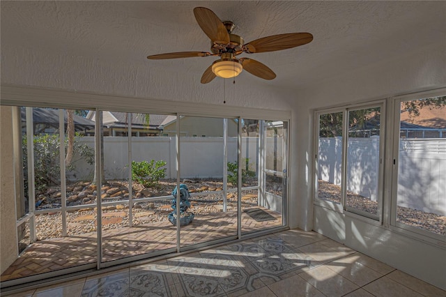 unfurnished sunroom with ceiling fan