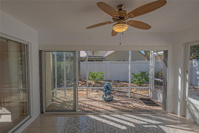 unfurnished sunroom featuring ceiling fan