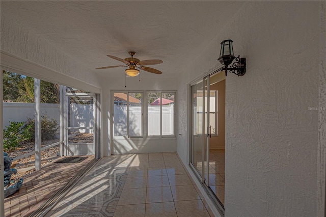 unfurnished sunroom featuring ceiling fan