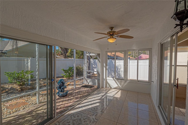 unfurnished sunroom with ceiling fan