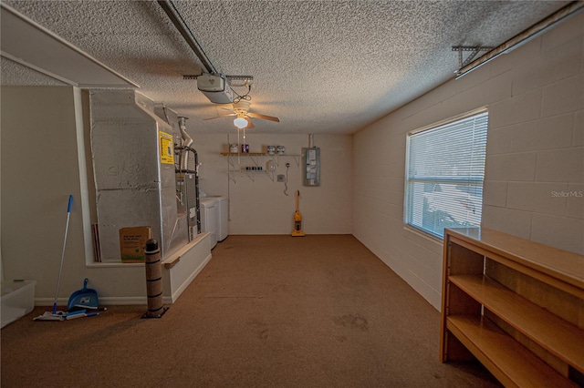 interior space with ceiling fan, a garage door opener, electric panel, and washing machine and clothes dryer