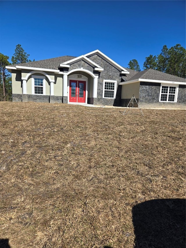 view of front of house featuring a front yard and french doors