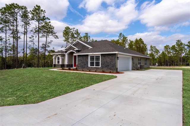 view of front of property featuring a garage, central AC, and a front yard