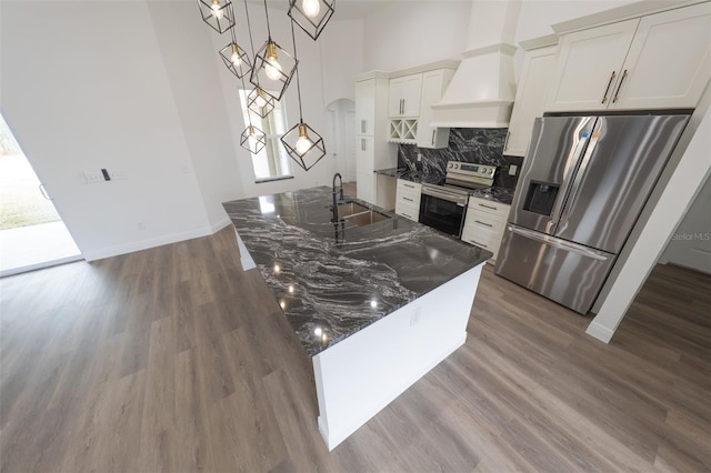 kitchen featuring premium range hood, pendant lighting, white cabinetry, sink, and stainless steel appliances